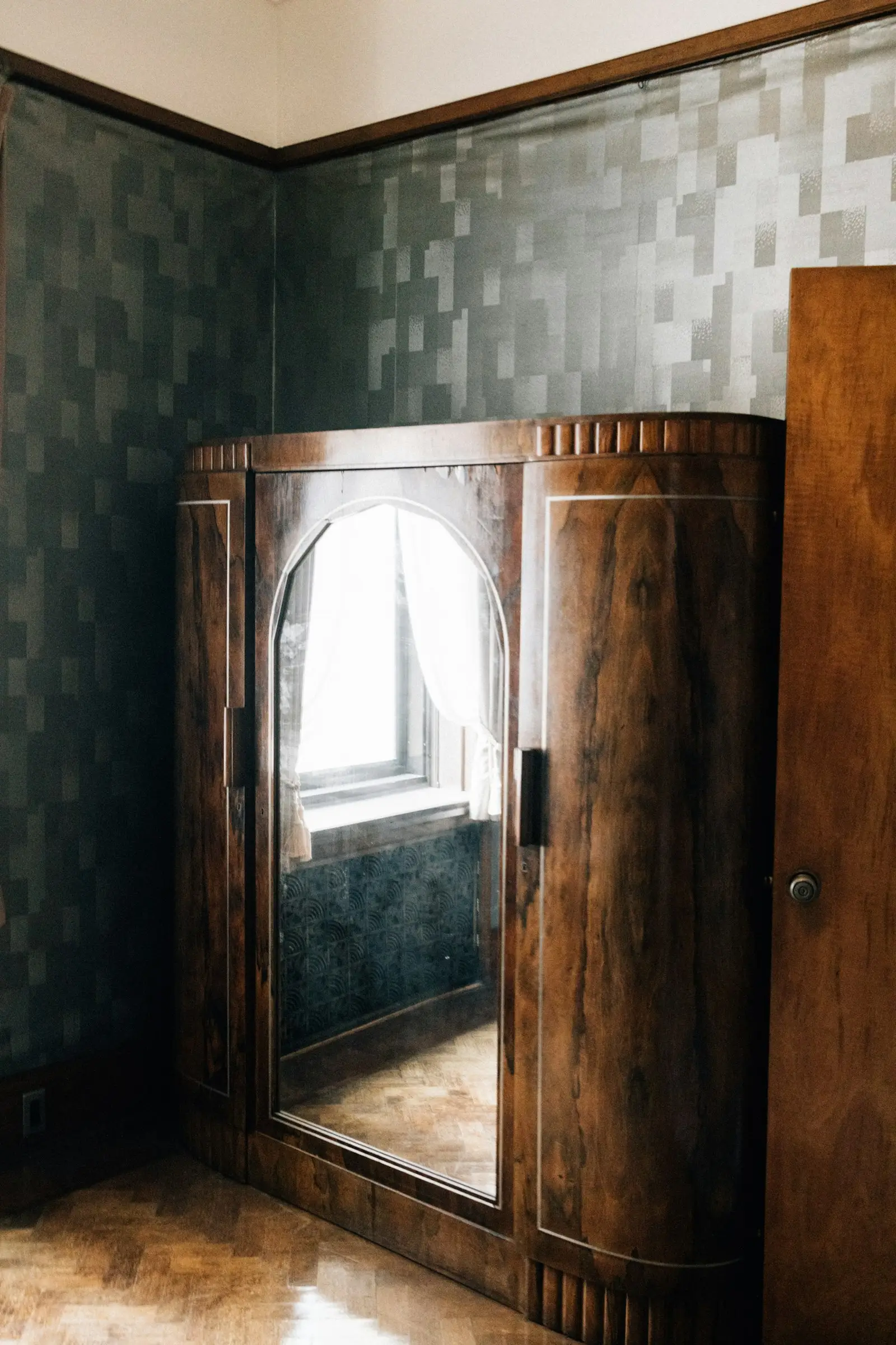 Ropero de madera con puerta de espejo y esquinas redondeadas